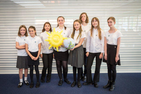 ECO2 Educational resources group of pupils with sunflower highlighting the role plants play in the environment